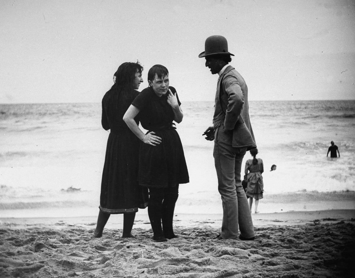 An actor talks with bathers on the beach, 1886.