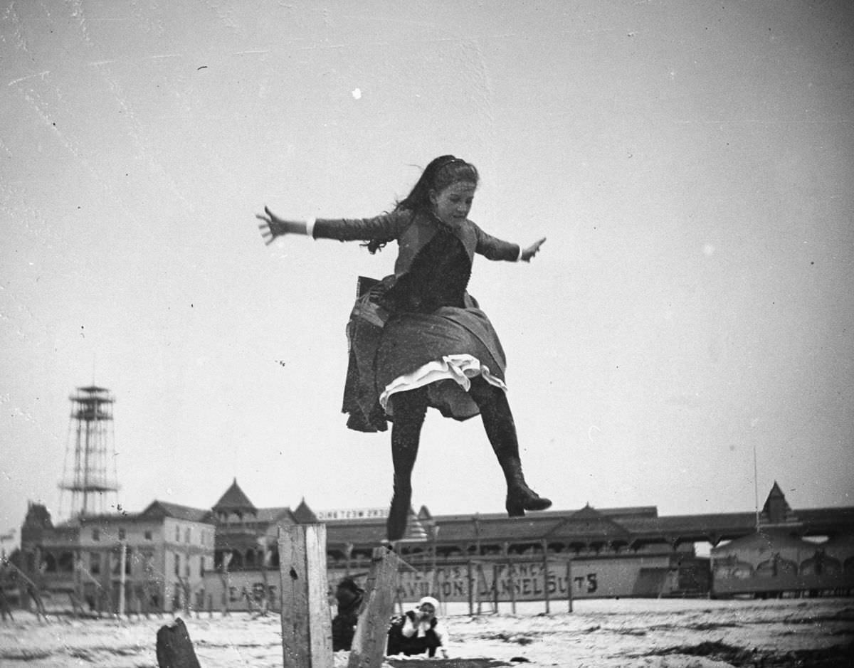 Edith Poey jumps off a wooden pole onto the sand at Coney Island, 1887.