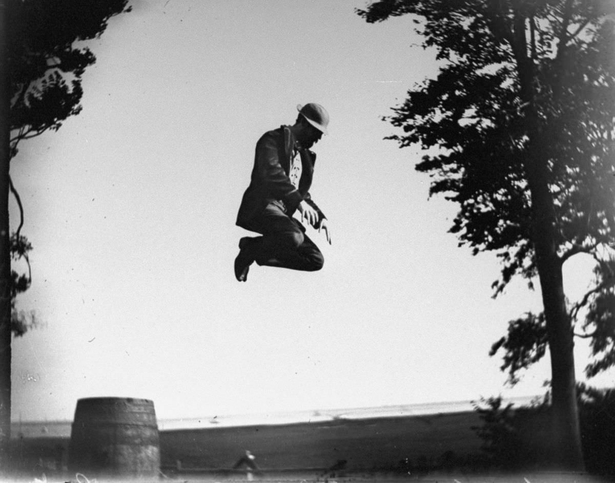 Edgar J. Taylor jumps off a barrel, 1887.
