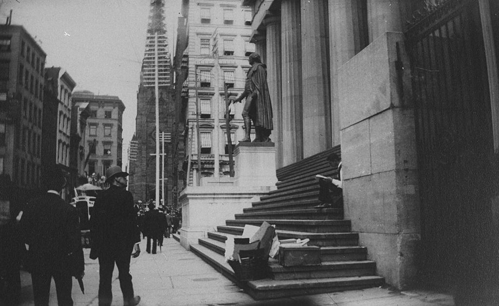 Men walking by the statue of George Washington on Wall St, New York, 1884.