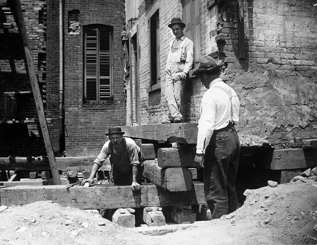 A foreman and two workers preparing a house at 314 Livingston St. for moving, New York, 1889.