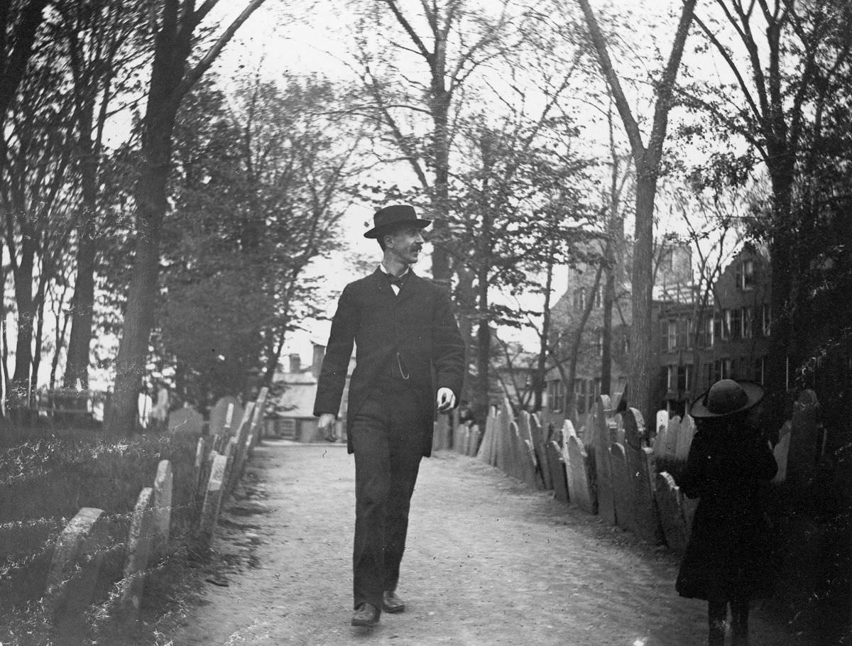 Nathan Abbott and a young girl walk through Copps Hill Cemetery, 1886.