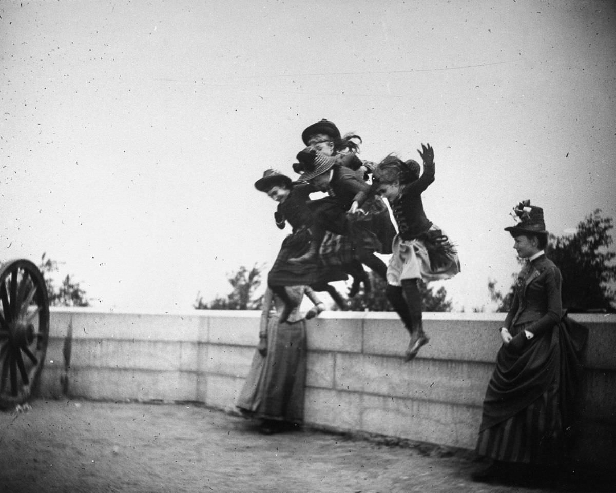 Girls jump off a stone wall in Fort Greene, 1886.