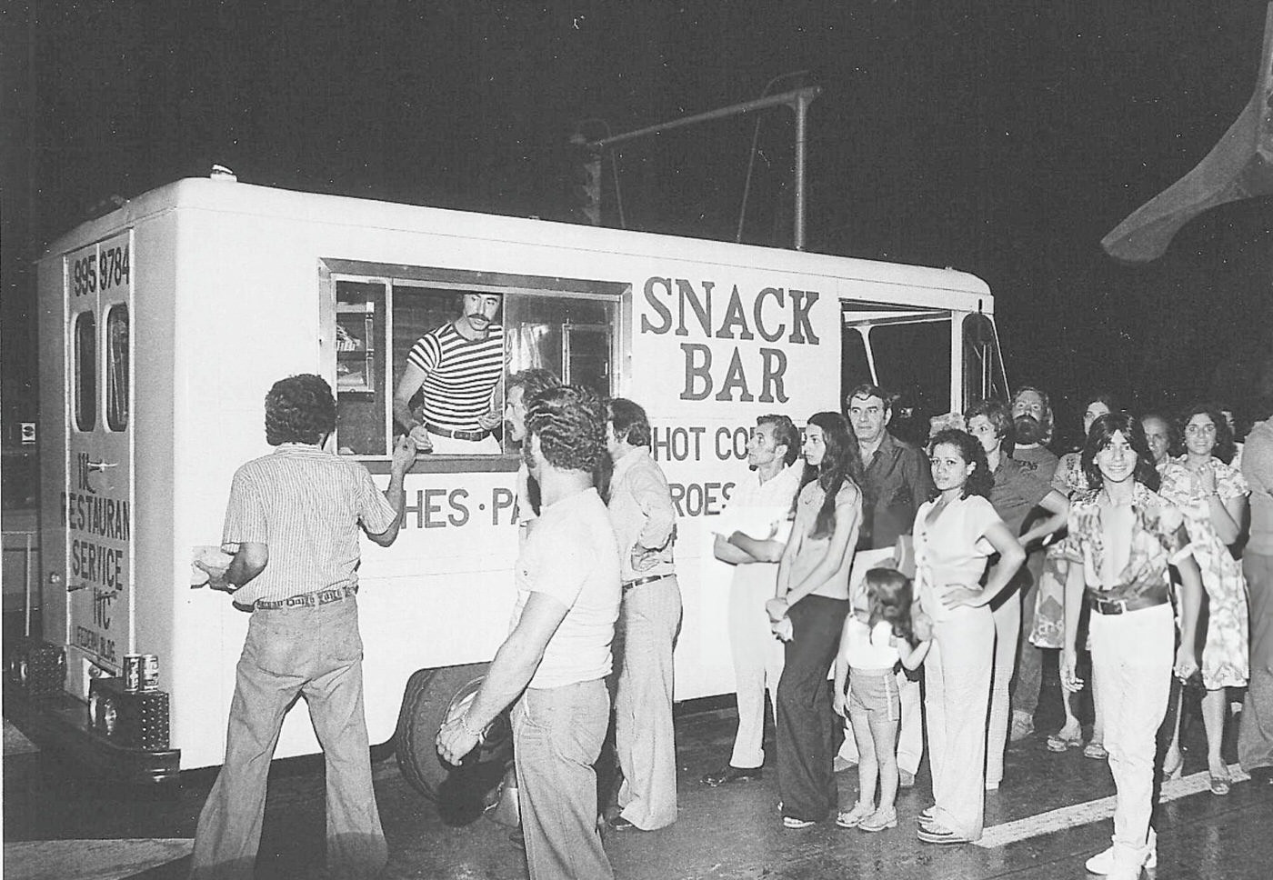 A crowd lines up at a snack truck at JFK Airport during the blackout, 1977.