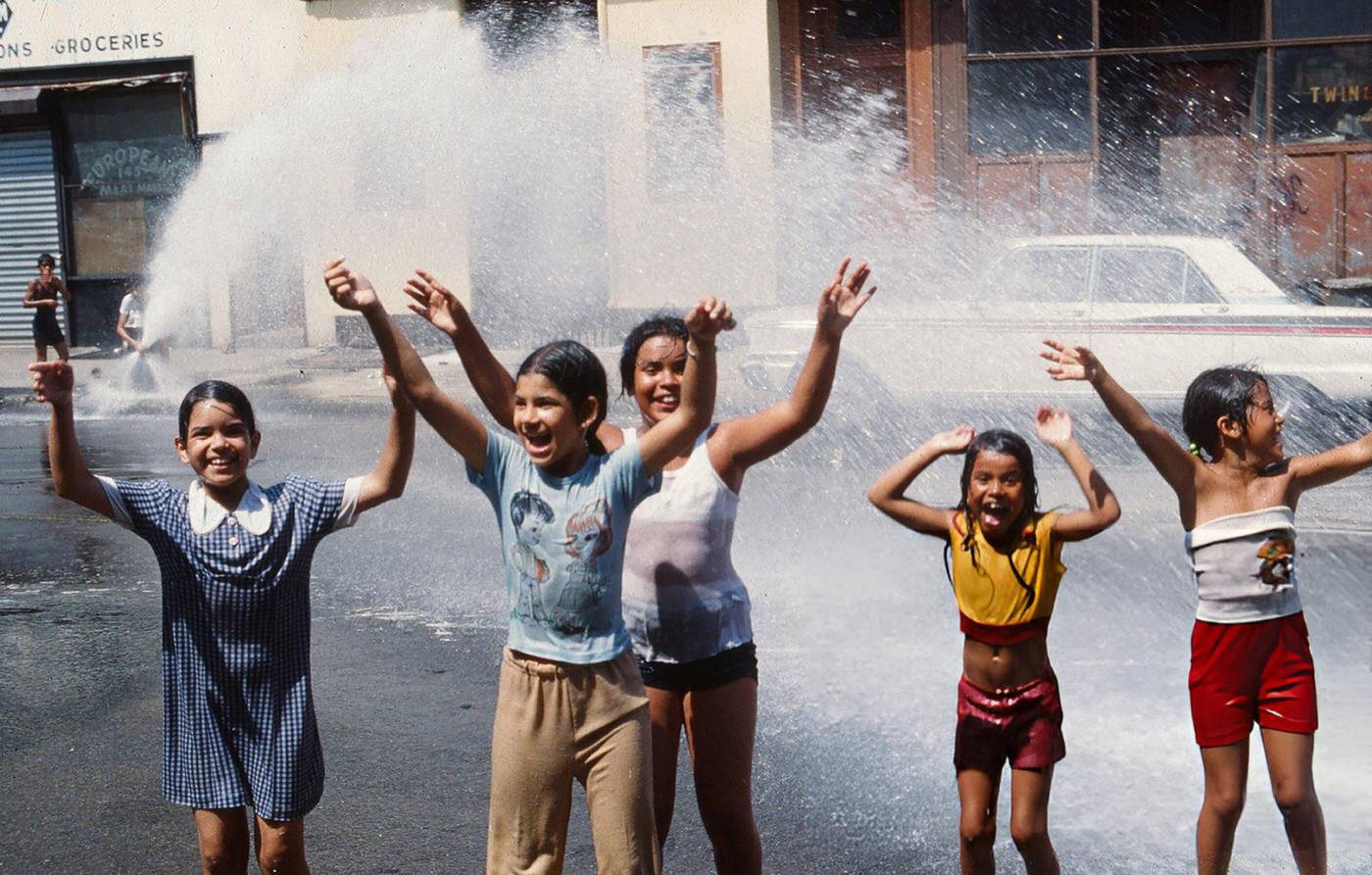 Girls play in the water from an opened fire hydrant in the wake of the New York City blackout, Brooklyn, 1977.