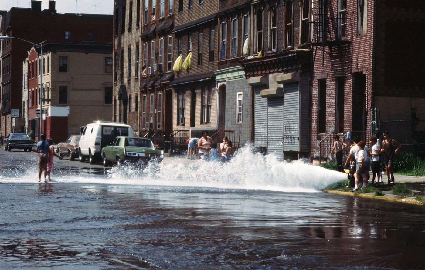 Children play in the water from an opened fire hydrant in the wake of the New York City blackout, Brooklyn, 1977.