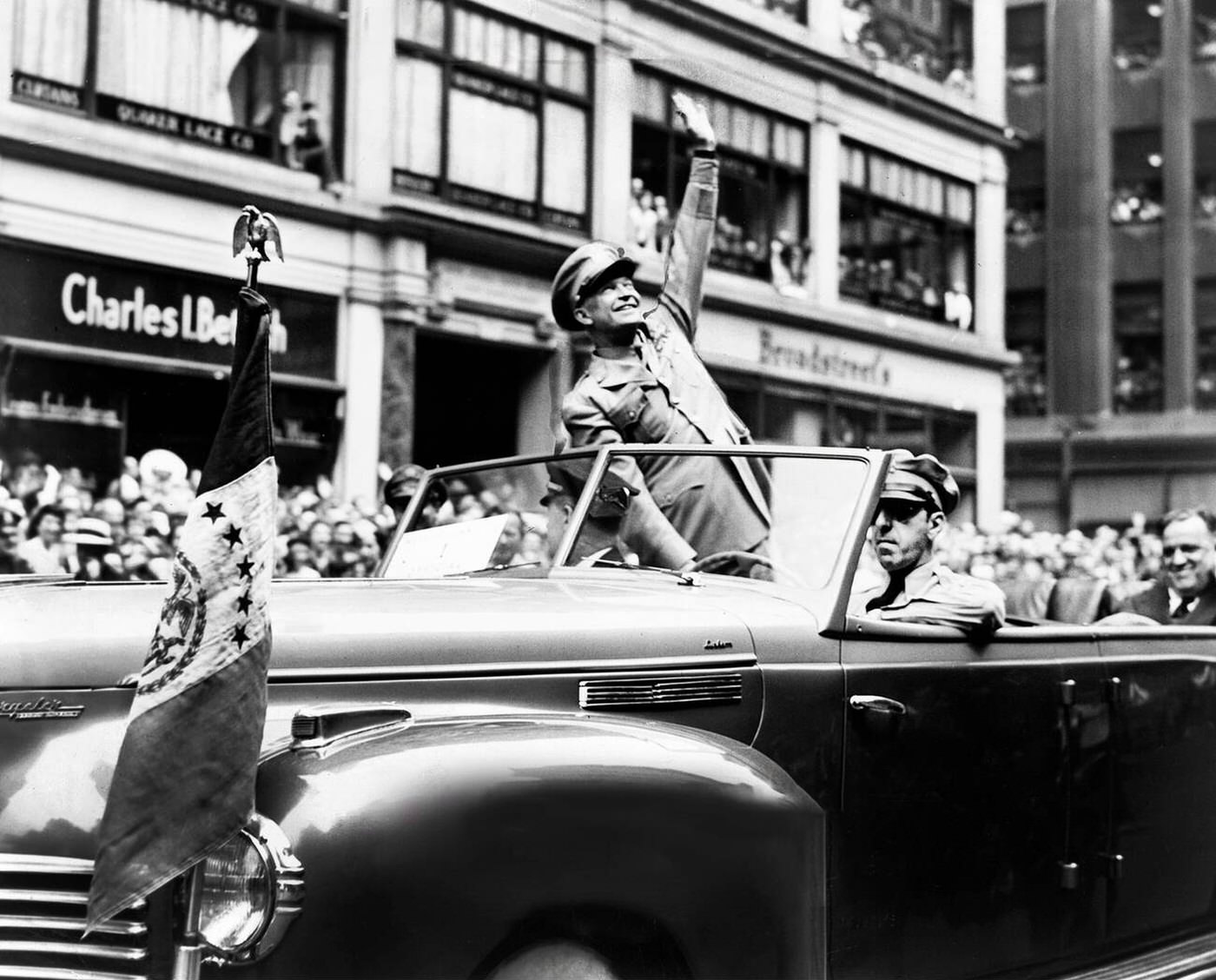 U.S. General Dwight D. Eisenhower waves from an automobile during a ticker tape parade, New York City, 1945.