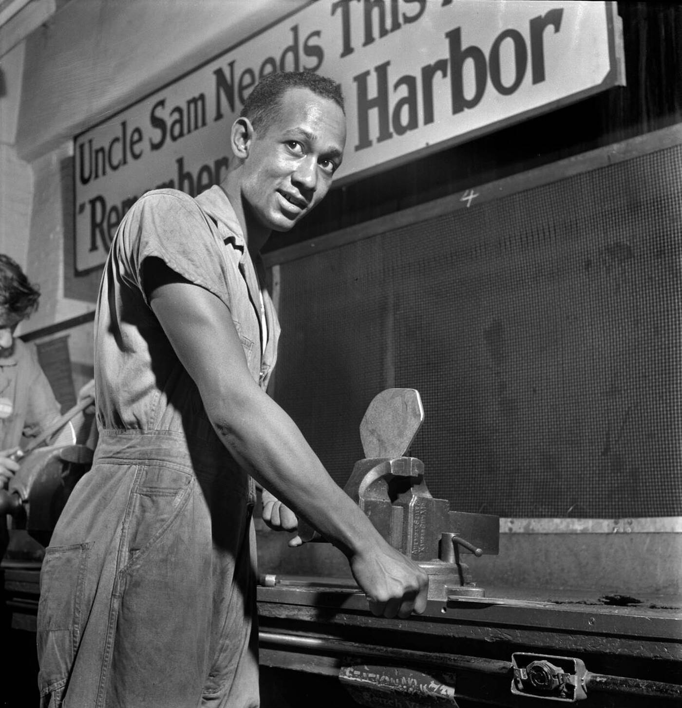 Young adult man receiving training in machine shop practice, National Youth Administration (NYA) Work Center, Brooklyn, New York, 1942.