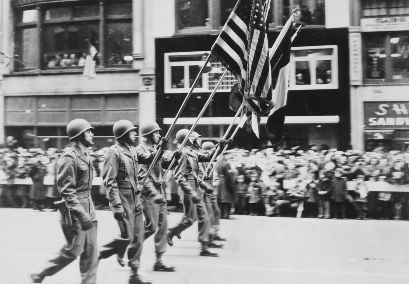 Soldiers marching with flags during a Victory Parade on Fifth Avenue, New York City, 1946.