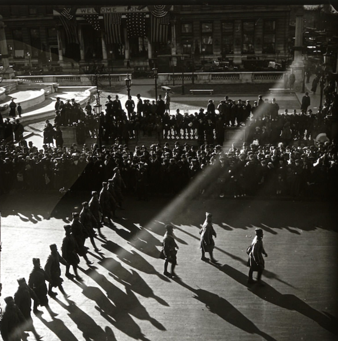 Late in the parade, with the sun low in the sky, possibly the Pulitzer Fountain in Grand Army Plaza outside the Plaza Hotel.