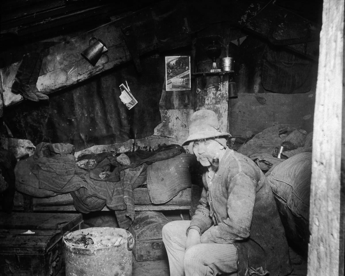 An Italian immigrant man smokes a pipe in his makeshift home under the Rivington Street Dump, 1890.