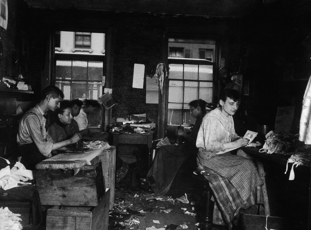 Men and women make neckties inside a tenement on Division Street in Little Italy, 1890.