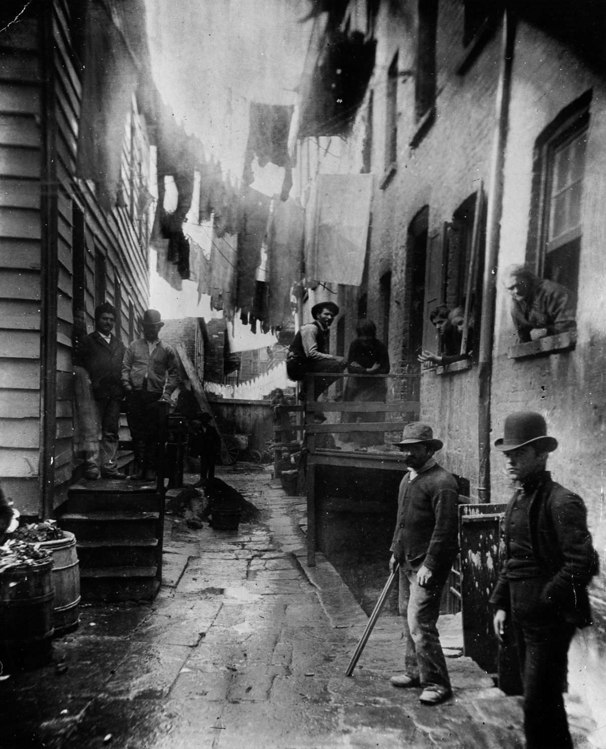 Men loiter in an alley off Mulberry Street known as "Bandits' Roost", 1888.