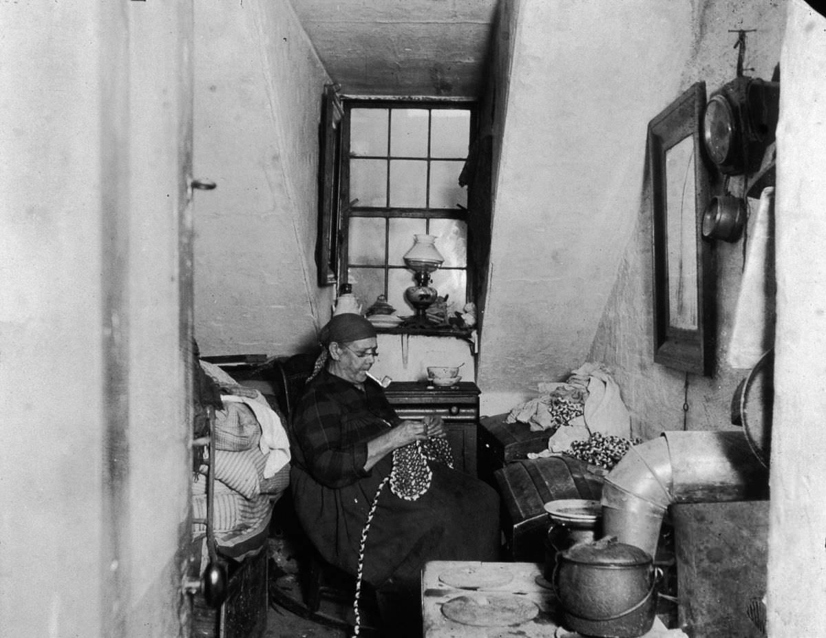 Mrs. Benoit, a Native American widow, sews and beads in her Hudson Street apartment, 1897.