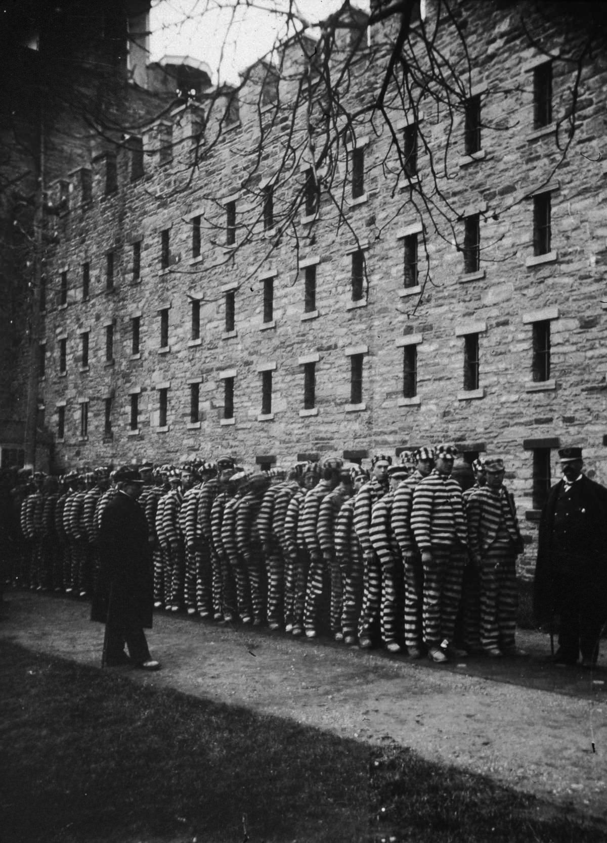 Prisoners are lined up at the Lock-step Penitentiary on Blackwell's Island (now Roosevelt Island), 1890.