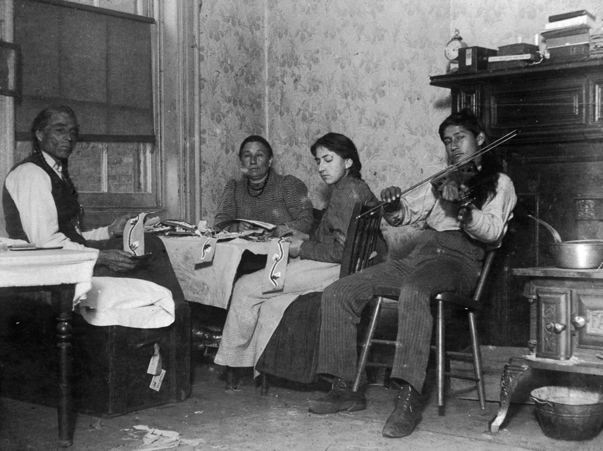 Mountain Eagle and his family make Native American handicrafts in their tenement at 6 Beach Street, 1895.
