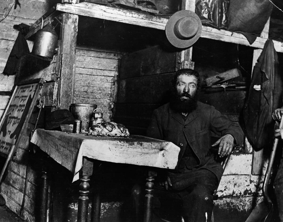 A Jewish cobbler ready for Sabbath Eve in a coal cellar where he lives with his family, 1887.