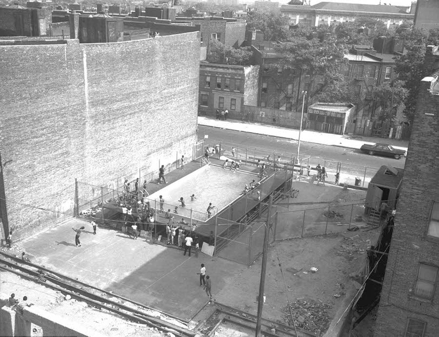 Swimmers taking a dip into a temporary pool at the Stroud Playground in Brooklyn, 1967.