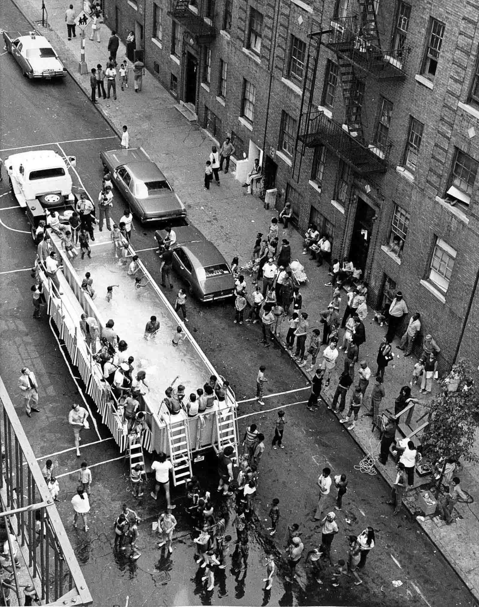 Dozens of children and adults crowded around a 'swimmobile', 1960s.