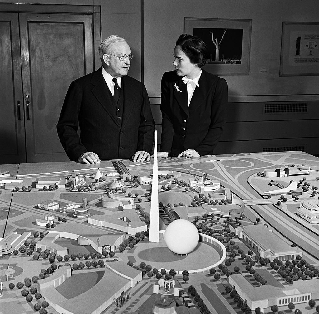 A man and woman stand in front of a model of the site of the 1939 New York World's Fair in Flushing Meadows, Queens, 1938.
