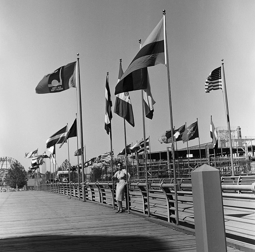 A woman stands under flags during the construction of the 1939 New York World's Fair in Flushing Meadows, Queens, 1938.