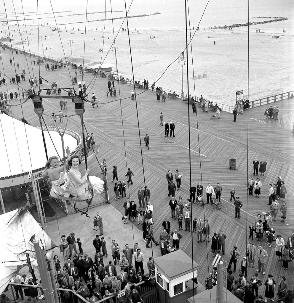 Models from the CBS gameshow, "The Big Payoff," ride The Parachute Jump at Steeplechase Park, 1950s.