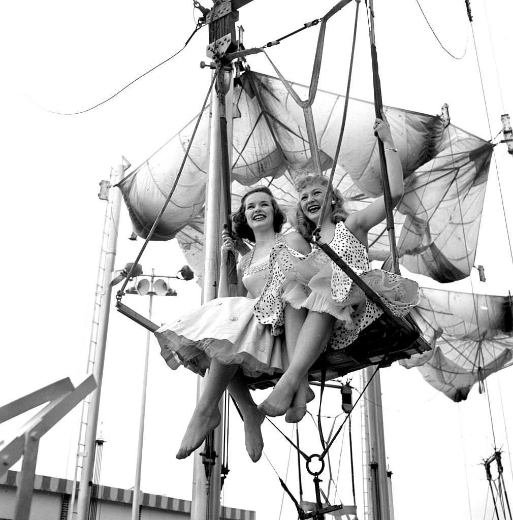 Models from the CBS gameshow, "The Big Payoff," ride The Parachute Jump at Steeplechase Park, 1950s.