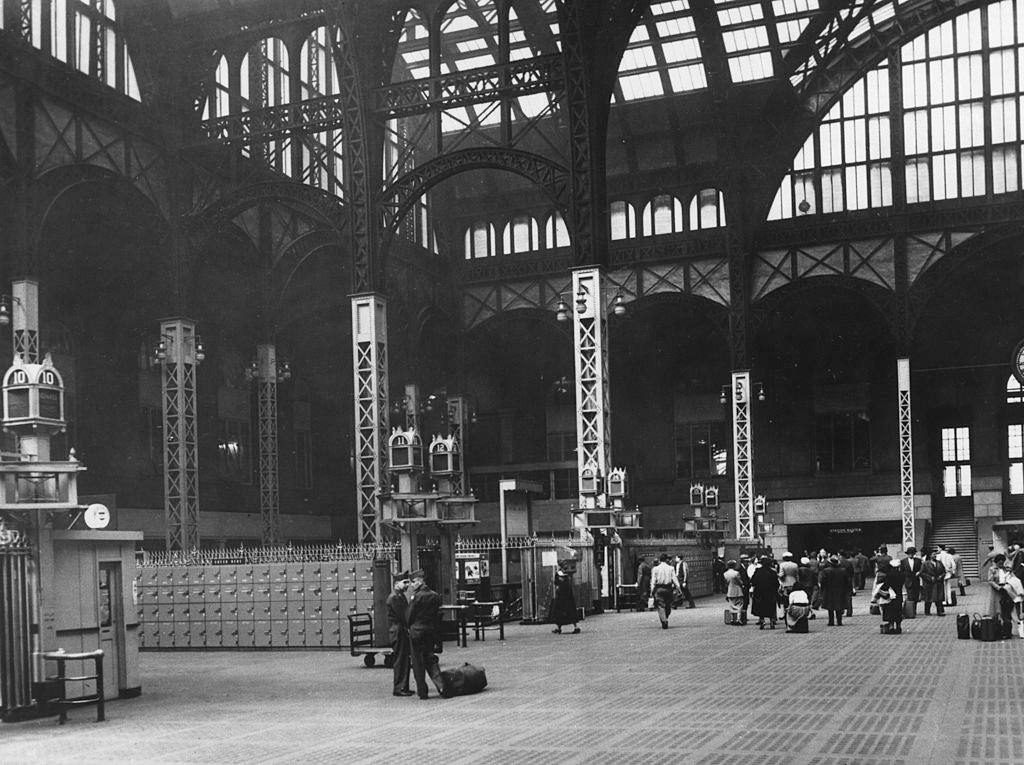 Passengers standing in the huge New York Pennsylvania Station Hall, 1950s.