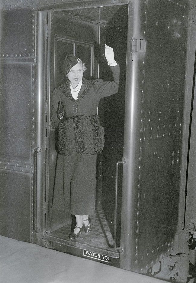 Lilyan Tashman waving in doorway at Penn Station, 1933.