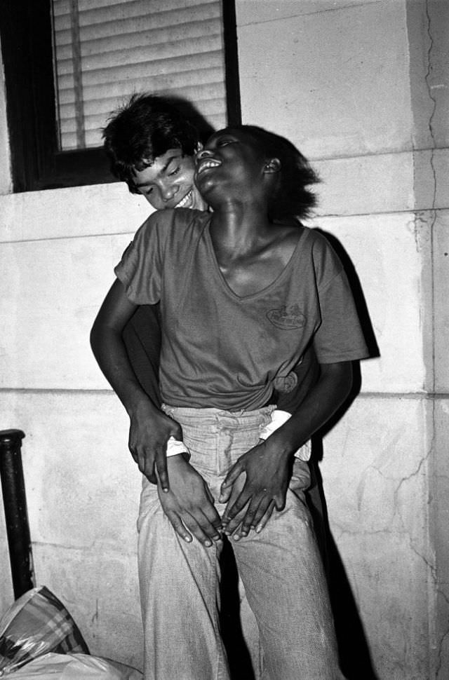Two young hustlers laugh and share a moment of joy between clients.
