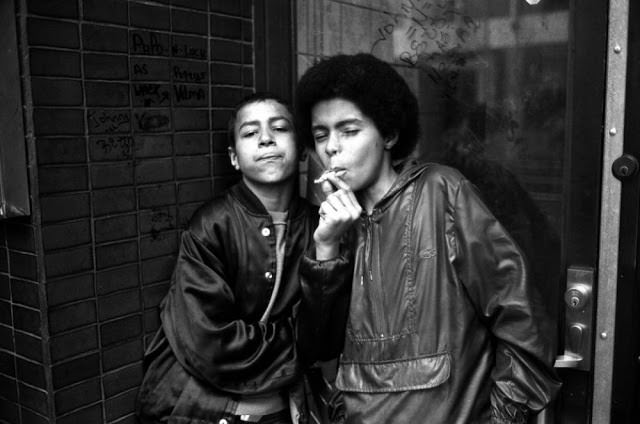 Teenage hustlers smoke a cigarette while waiting for customers on 7th Avenue near 42nd Street.