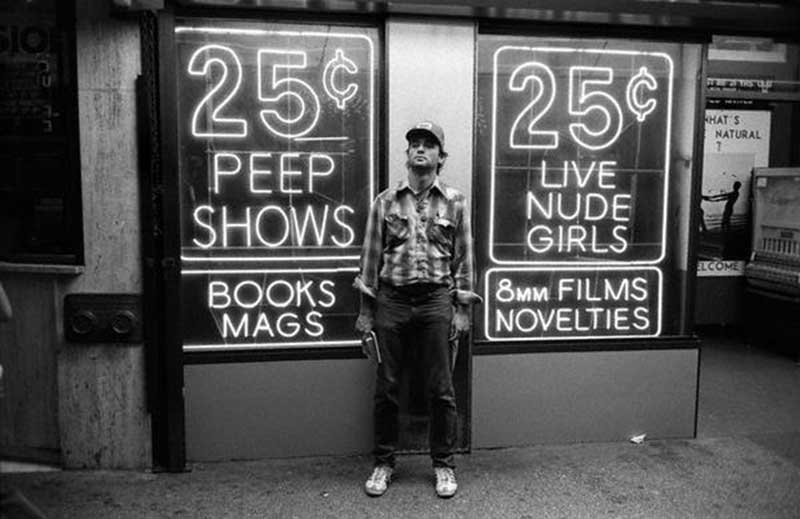 Actor Bill Murray poses in front of one of Times Square’s infamous 25-cent peep show signs in the mid-1970s.