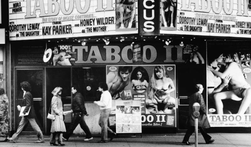 Pedestrians walk by without reacting to a theater promoting Taboo II, reflecting how normalized such imagery had become.