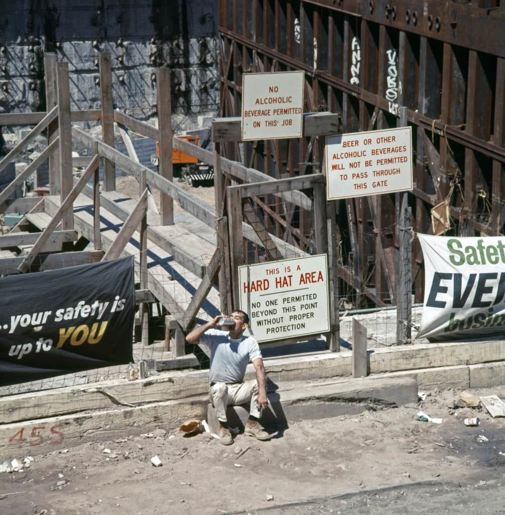 A construction worker drinks from an insulated flask outside the World Trade Center construction site, 1969.