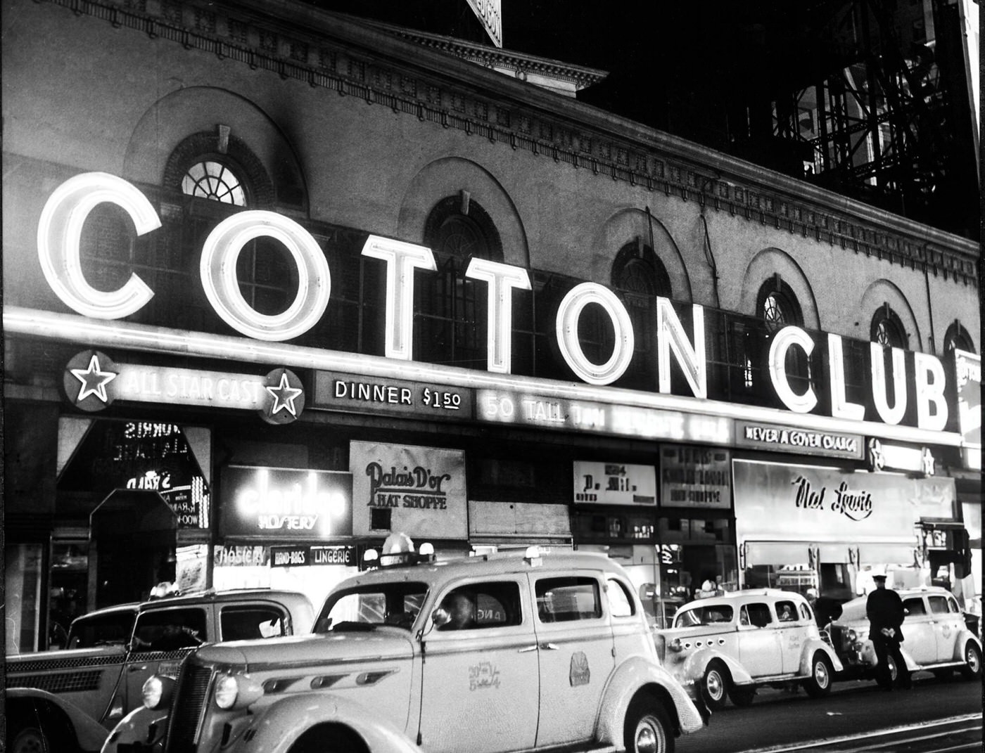 Signs Outside The Cotton Club At Night.