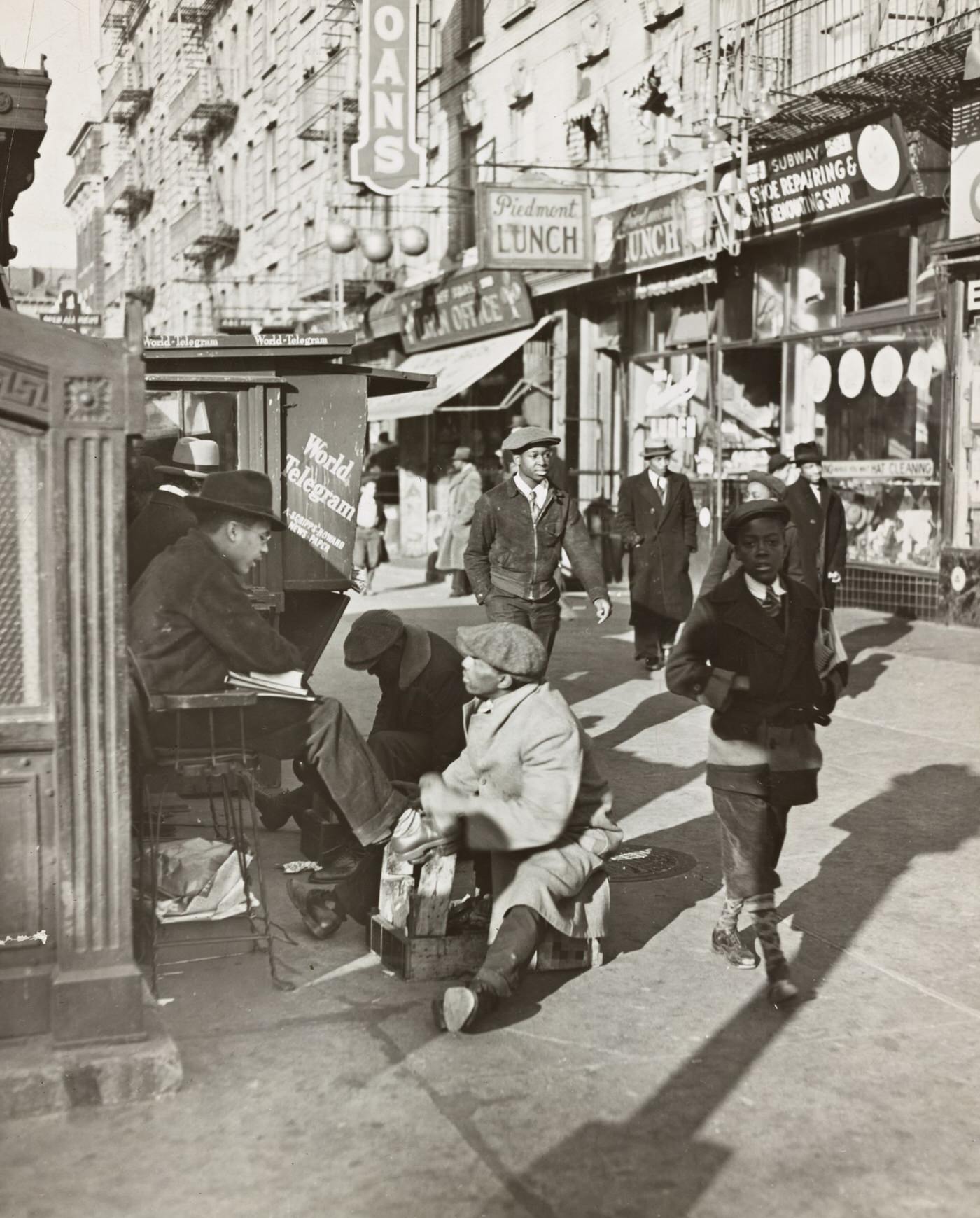 View Of Lenox Avenue, Harlem, At 135Th Street, Showing Businesses, Pedestrians, And A Shoeshine Stand, 1939.