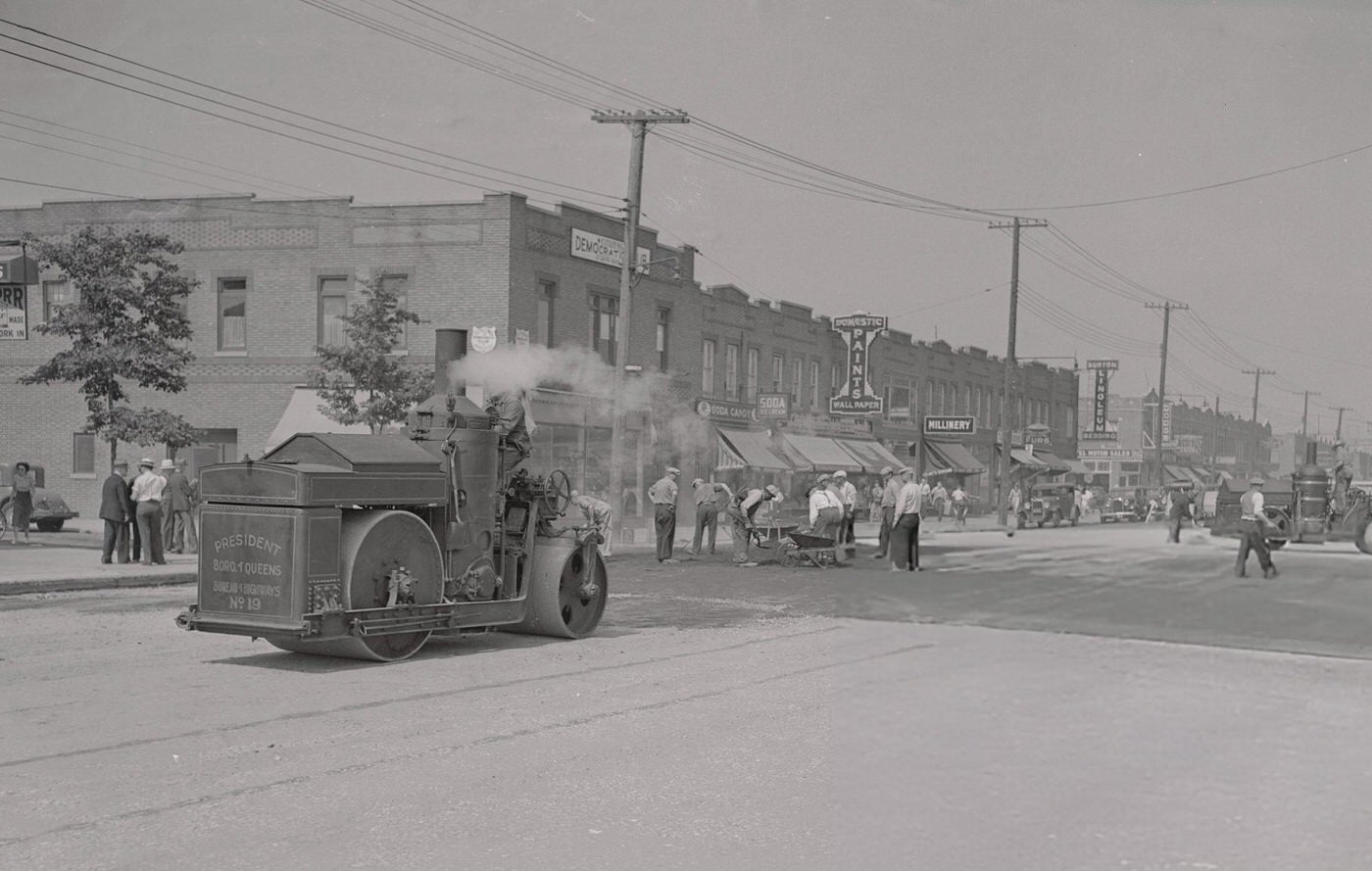 A steamroller with the Queens insignia operates on a WPA-abandoned project on Jamaica Avenue.
