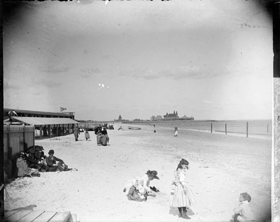 Beachgoers On Brighton Beach With The Manhattan Beach Hotel In The Distance, 1890S.