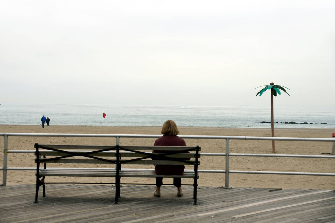 A Solitary Woman Sits On A Bench On The Boardwalk, Brighton Beach, 2008.