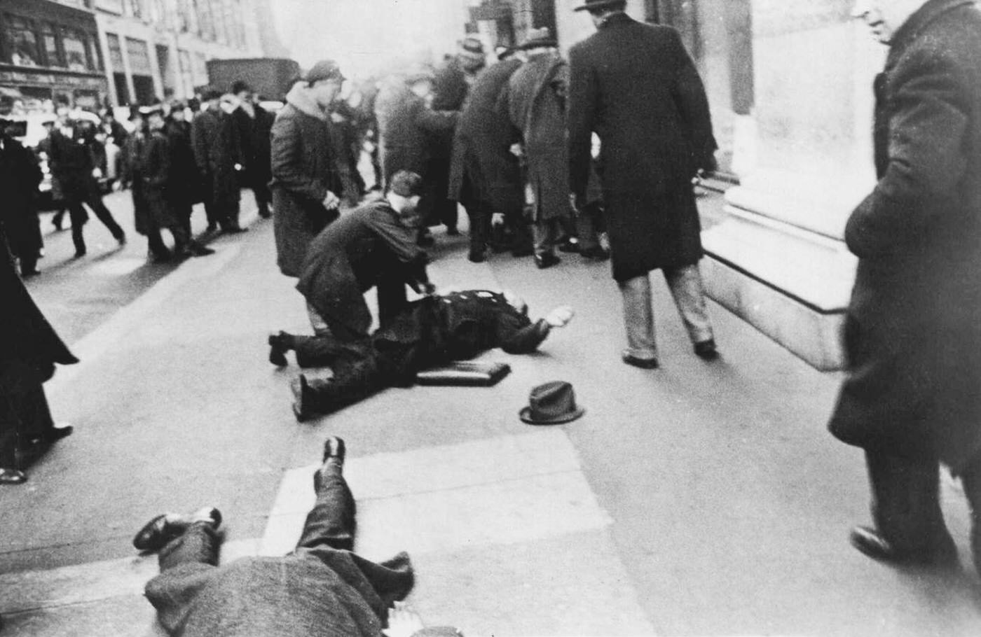 Spectator Leans Over The Body Of Patrolman Maher On Fifth Avenue And 34 Street, Undated.