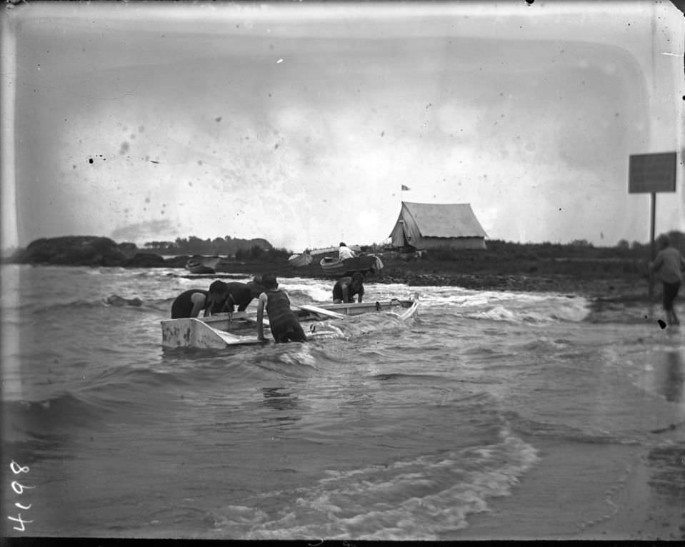Boys Trying To Raise A Rowboat Full Of Water At Orchard Beach, Bronx, 1907.