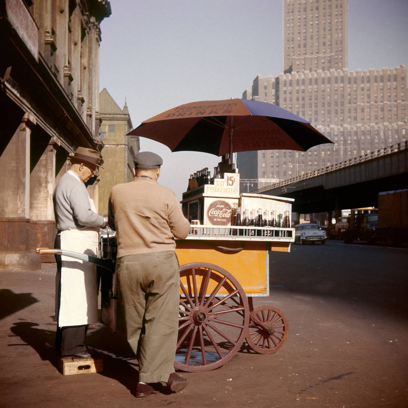 Hot Dog Vendor With Pushcart And Umbrella Selling Cokes For 15 Cents, West Street Downtown Manhattan, New York, 1950S.