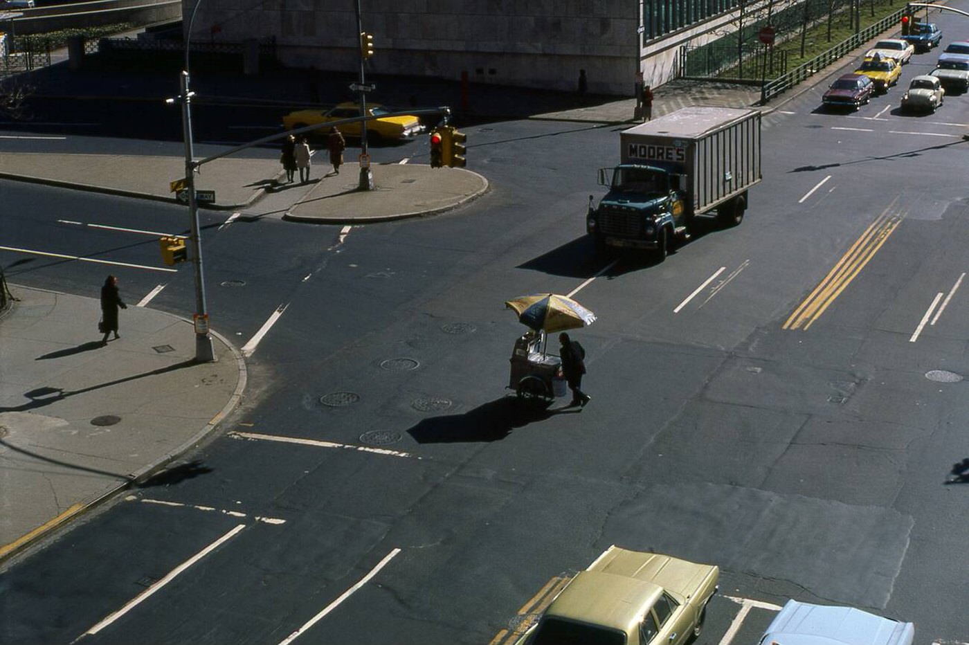 Man Pushing Food Vending Cart Through Intersection In Midtown Manhattan, New York, Early 1980.