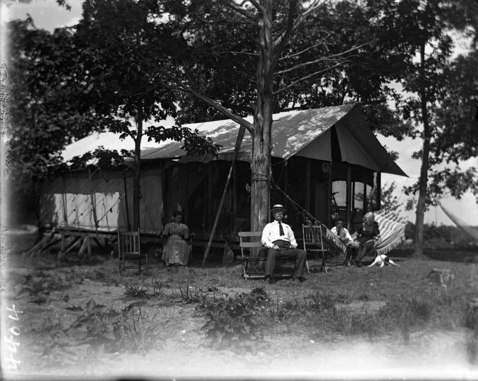 Campsite Decorated For Labor Day With Unidentified Family Seated In Front At Orchard Beach, Bronx, 1910.