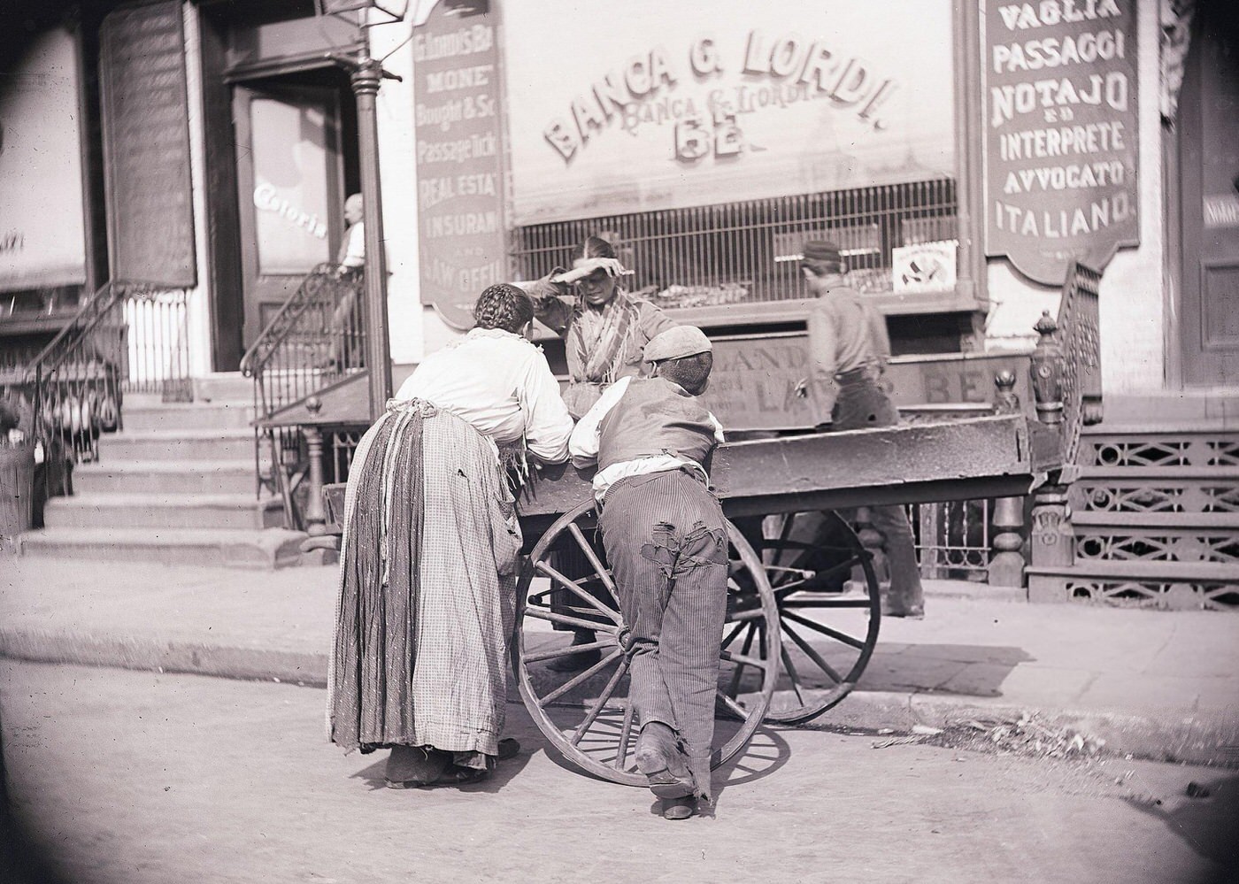 A Boy And A Woman Lean On A Pushcart Belonging To A Mulberry Street Huckster, 1900.