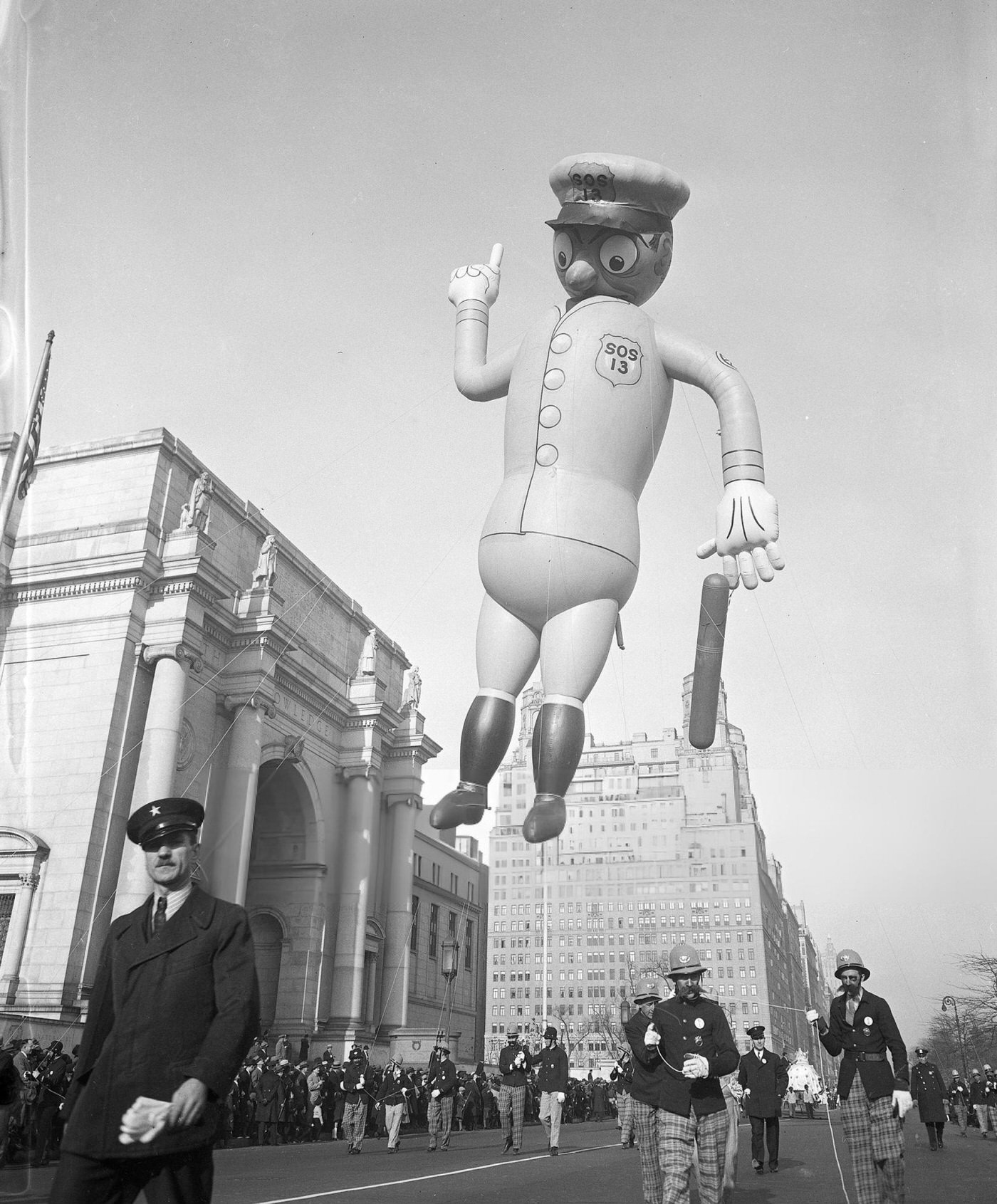 A Parade Balloon In The Shape Of A New York City Cop Is Led Down The Street During The Annual Macy'S Thanksgiving Day Parade, 1930S.