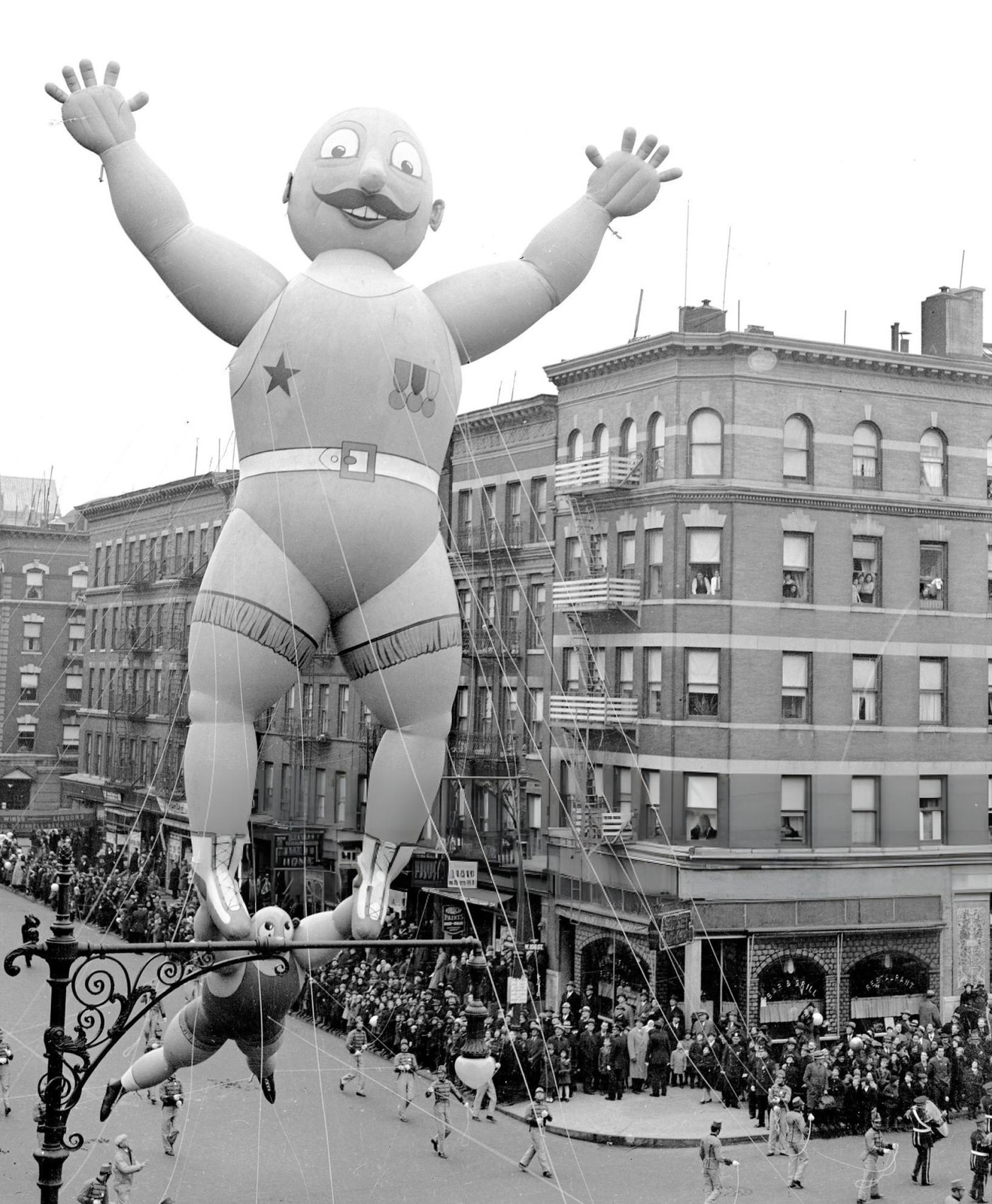 A Prize-Winning Balloon Of Two Acrobats, Designed By 12-Year-Old Rudolf Lopez, Passes 106Th St. And Central Park West In Macy'S Thanksgiving Day Parade, 1938.