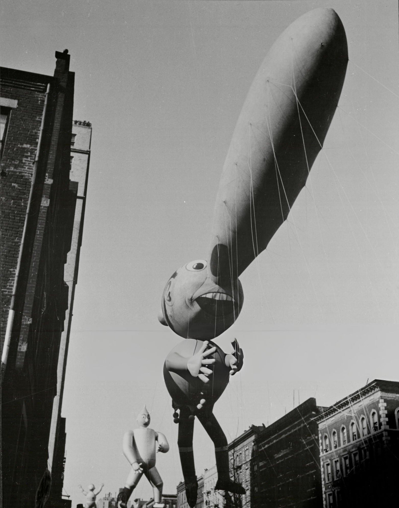 A Pinocchio Balloon, Followed By Tin Man And Trapeze Artist Balloons, In Macy'S Thanksgiving Day Parade In New York City, 1939.