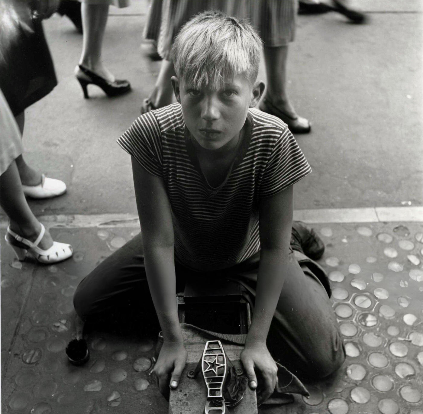 Boy In A Striped Shirt Kneels On The Sidewalk With His Shoeshine Box, Ready For The Next Patron, New York, 1947.