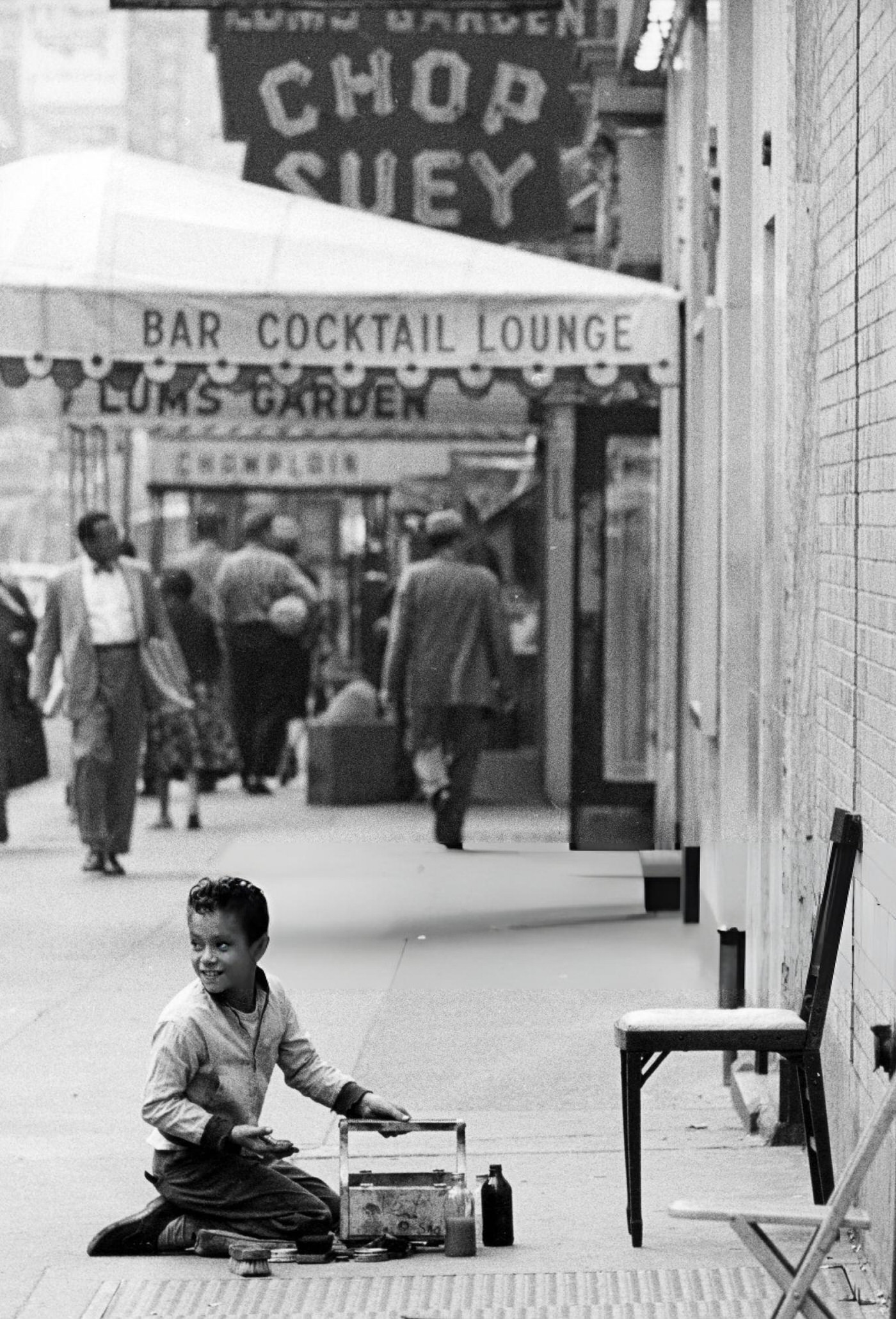 A Shoeshine Boy Smiling While Kneeling In The Street In Broadway, New York, 1960S.